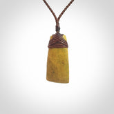 Hand carved from a lovely piece of local New Zealand Flower Jade. We have suspended this from a 3-plait brown cord which can be adjusted with a couple of slip knots and brown binding.